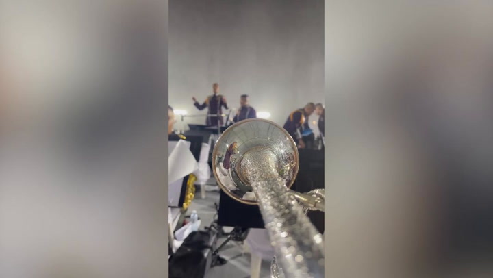 Marching band plays on through powerful storm at colleagues' retirement party
