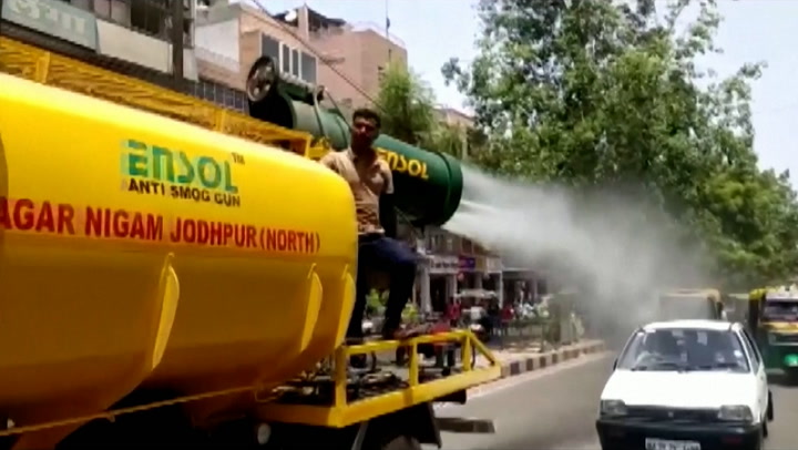 Sprinklers and scarves help Indians seek relief from heat wave