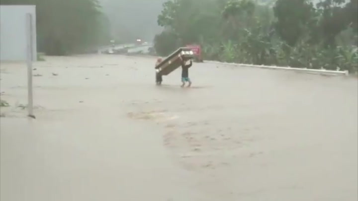 Coffin carried down flooded street amid Typhoon Rai