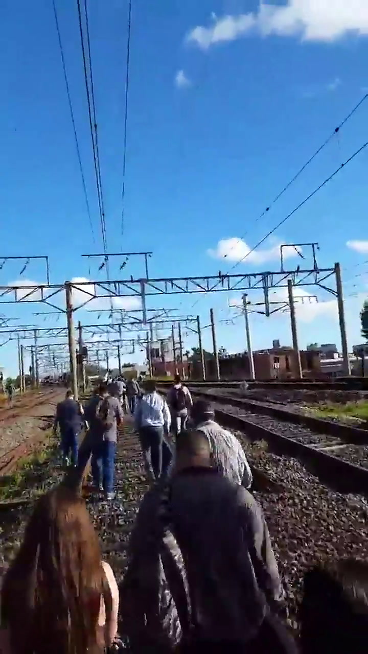 Pasajeros caminan por las vías del tren Roca luego de in incidente - Fuente: Twitter