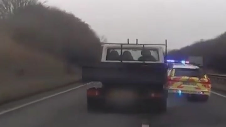 Banned driver rams police car off the road during dramatic high-speed chase