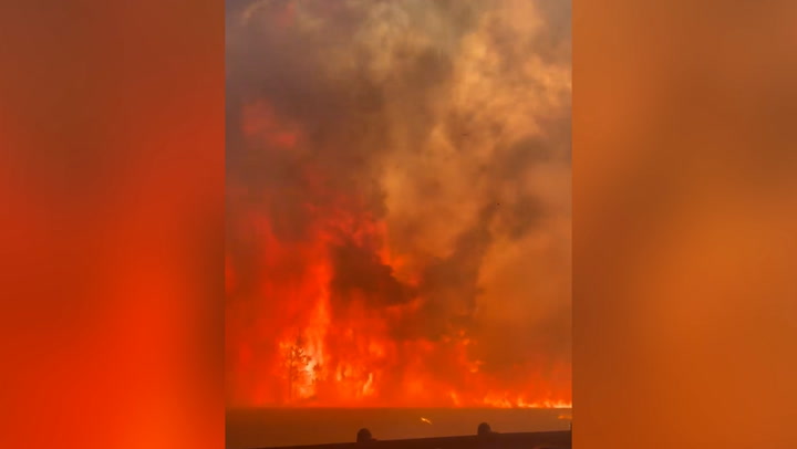 Huge wildfire flames tower over Texas emergency workers