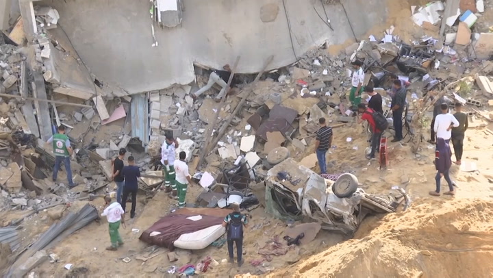Gazans pick through rubble of destroyed building.mp4