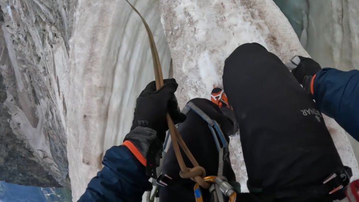 Climber navigates narrow snow bridge above 3,000-metre high crevasse in the French Alps