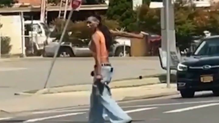 Woman waves gun at busy intersection