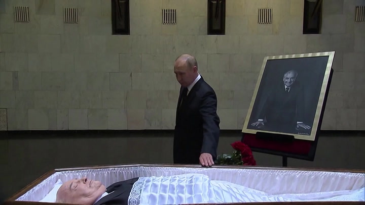 Vladimir Putin lays flowers next to open coffin of Mikhail Gorbachev