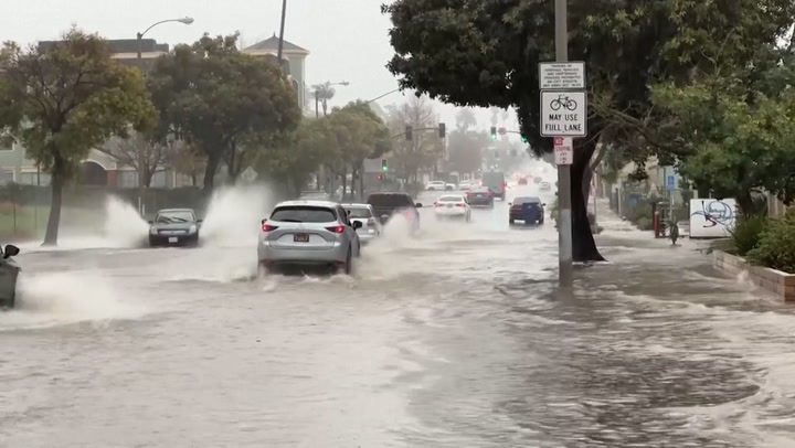 Cars drive through submerged roads as 'life-threatening' flooding hits California