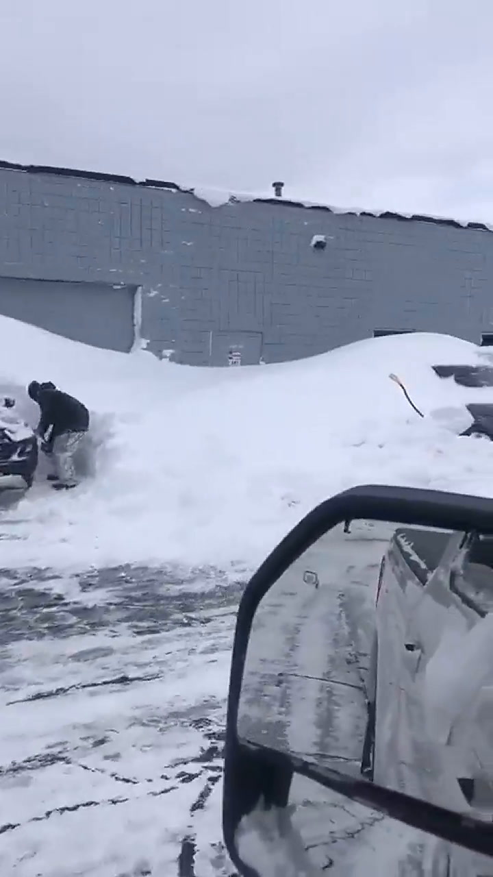 Los jugadores de Buffalo Bills mientras desentierran sus coches que están bajo la nieve
