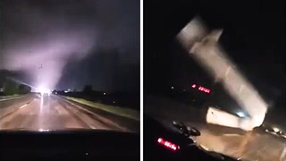 Flying debris narrowly misses car as tornado rages near highway