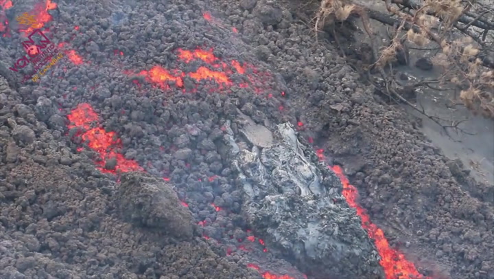 River of lava carries a chunk of rock downhill from La Palma volcano
