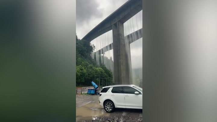Water plummets from bridge after heavy rain in China