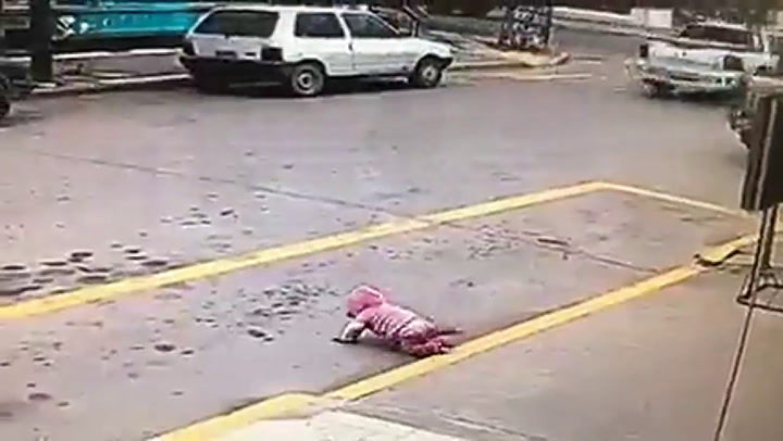 El momento en que una beba es salvada mientras cruza la calle gateando
