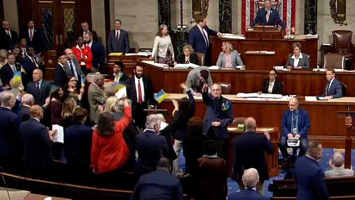 Representatives celebrate and wave flags after Congress passes Ukraine aid package