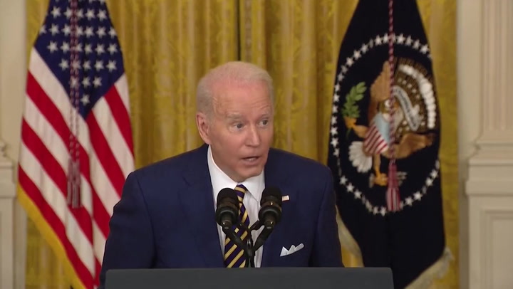 Biden leans over microphone and slowly whispers to female journalist
