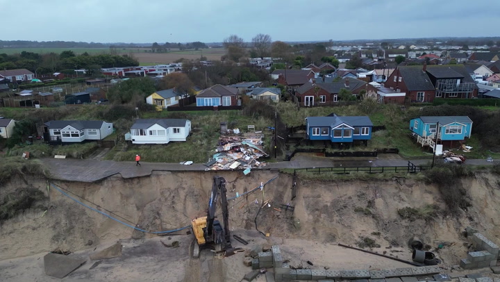 Demolition teams tear down clifftop homes suffering from coastal erosion in Norfolk village