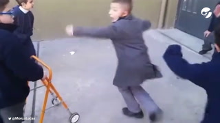Un nene con discapacidad es ayudado por sus compañeros a meter un gol