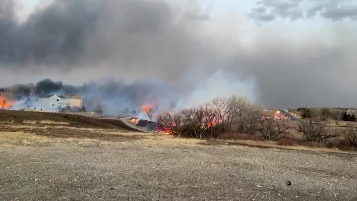 Homes engulfed in flames and winds blow wildfire across Colorado