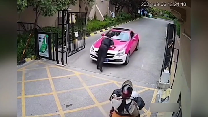 Female Mercedes driver drives away with security guard on the bonnet in China
