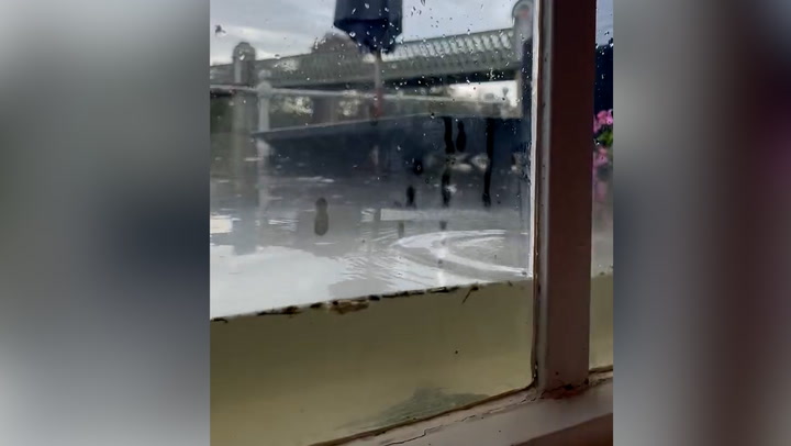 Water rises above windows of riverside London pub