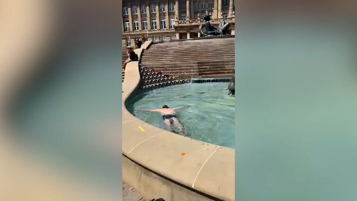 Man swims around in Birmingham fountain to cool off during UK heatwave