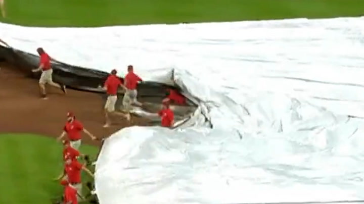 Hilarious moment crew member swallowed by tarpaulin at MLB baseball game