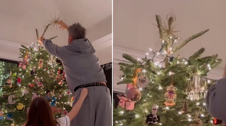 Robbie Williams struggles to put star on top of Christmas tree in family video