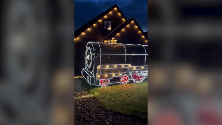 Father and son turn front hedge into Polar Express-themed light display for Christmas