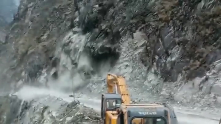 Giant cliff face collapses onto road as people run for their lives