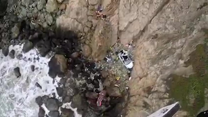 Two adults and two children rescued after Tesla plunges 250ft off California cliff
