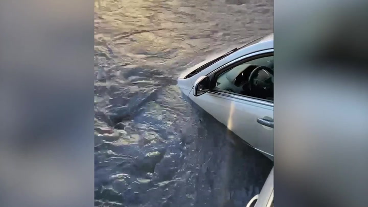 Car 'swallowed' by water hole caused by mains rapture