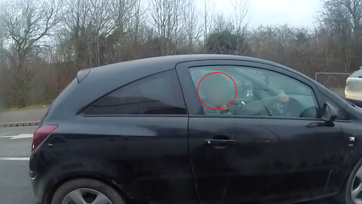 Driver using his phone puts middle finger up to undercover police