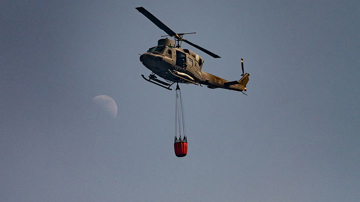 Helicopters douse flames of raging wildfires in Italy