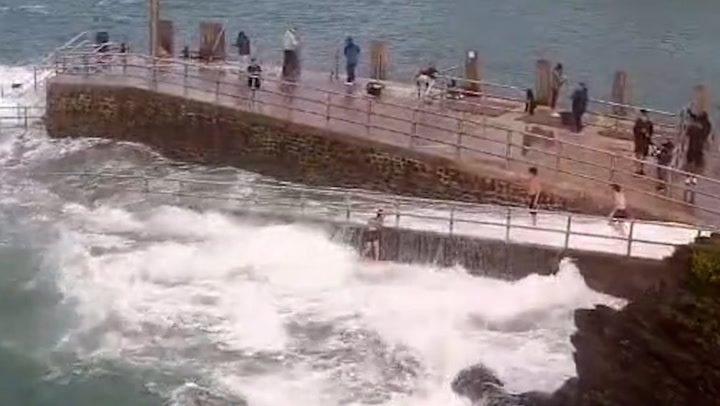 Child swept into sea after waves pummel Devon harbour