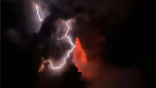 Volcanic lightning turns the night sky red during eruption