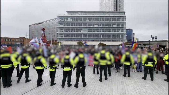 Police form line between protesters from both sides of transgender debate in Belfast