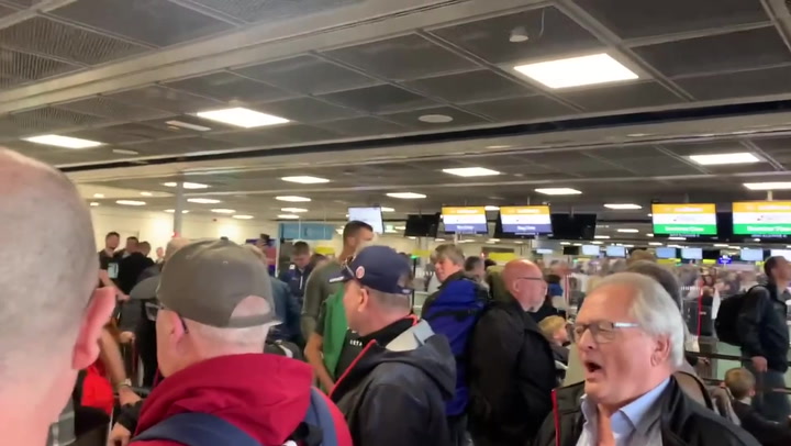 Dublin airport passengers sing together as they face long check-in queue