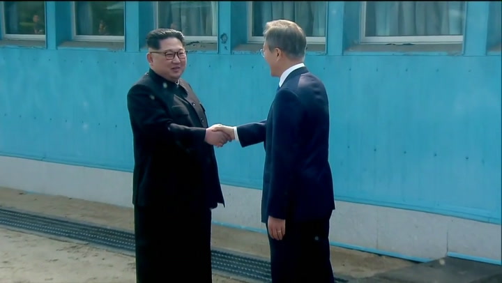 El líder norcoreano Kim y el presidente surcoreano se dan la mano en la línea de la frontera - Fuent
