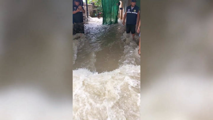 Surging flash floods gush through homes in Thailand