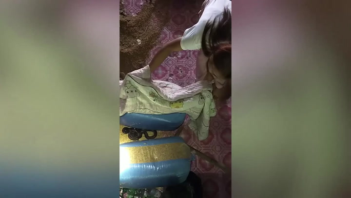 Housewife catches huge snake hiding in kitchen using blanket