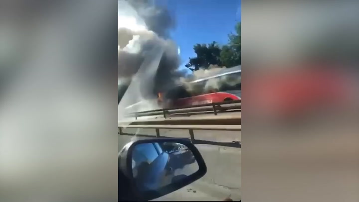 Smoke and flames billow into air after bus catches fire 'with customers on board'