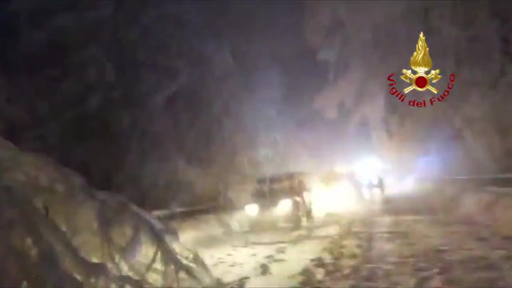 Firefighters clear roads and remove fallen trees after heavy snow in Italy