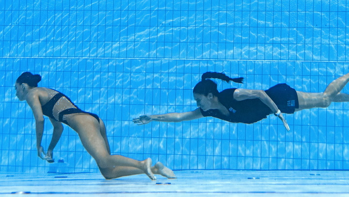 Swimmer’s coach dives into pool to save her after fainting during world championships